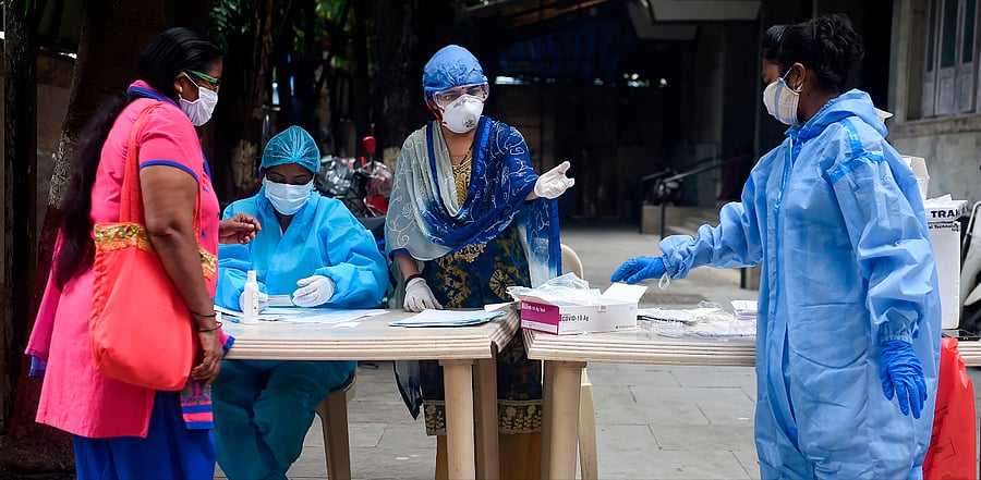 Health workers talk with a resident during a medical screening for the Covid-19 in Mumbai. Credit: AFP Photo