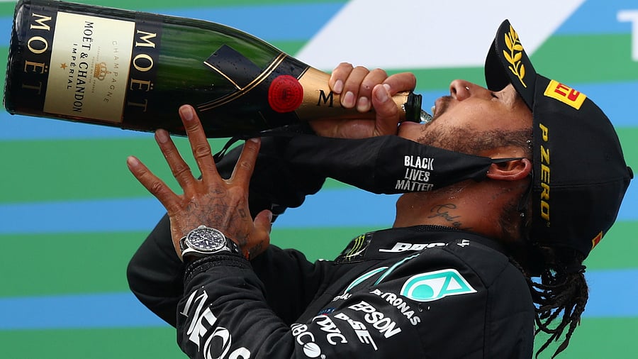 Mercedes' Lewis Hamilton celebrates with sparkling wine on the podium after winning the race Pool. Credits: Reuters Photo