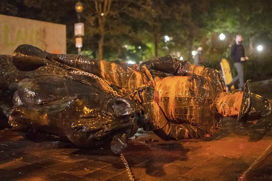 Protesters walk past a toppled statue of President Theadore Rosevelt during an Indigenous Peoples Day of Rage protest on October 11, 2020 in Portland, Oregon. Protesters tore down statues of two U.S. presidents and broke windows out of downtown businesses Sunday night before police intervened. Credit: Getty Images/AFP