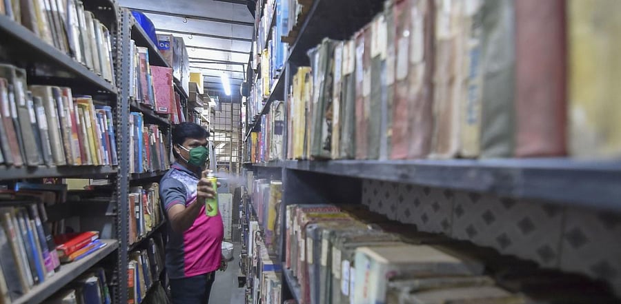 A worker sanitizes a library ahead of its reopening, during Unlock 5, amid the coronavirus pandemic, in Mumbai. Credit: PTI Photo