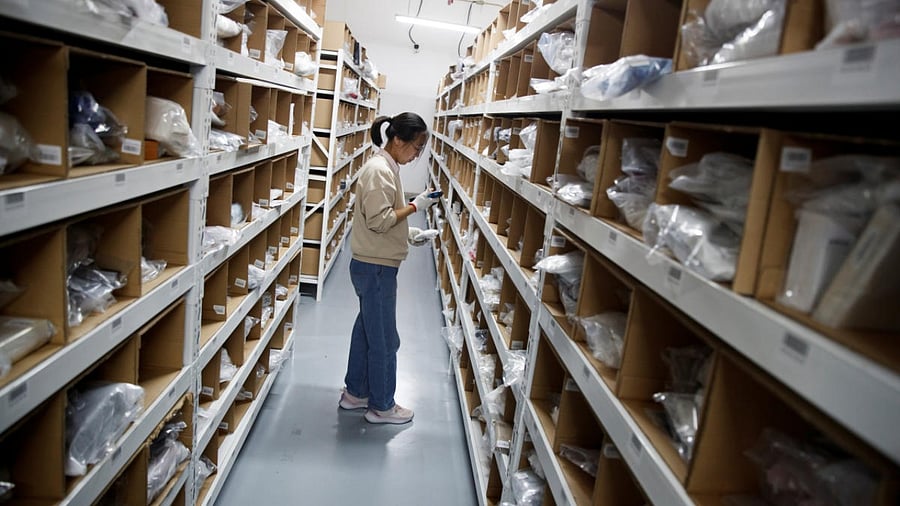 A staff member collects an order from the shelves at the warehouse of the second-hand luxury goods retail platform Plum. Credit: Reuters.