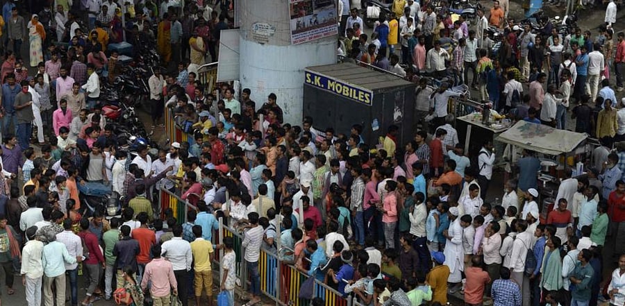Labourers stand along the roadside as they wait to be hired for daily wages in Hyderabad on October 15, 2020. Credit: AFP Photo