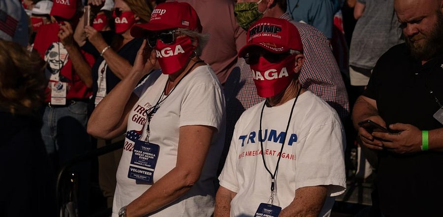 Attendees wait to hear President Donald Trump speak at a campaign rally. Credit: AFP