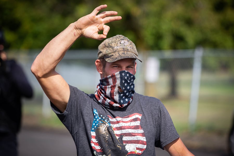 A man, member of the Proud Boys and other similar groups, gestures the OK sign that is now seen as a symbol of white supremacy, as hundreds gathered to rally for several hours at Delta Park in Portland, Oregon on September 26, 2020. - Far-right group "Proud Boys" members gather in Portland to show support to US president Donald Trump and to condemn violence that have been occurring for more than three months during "Black Lives Matter" and "Antifa" protests. Credit: AFP Photo