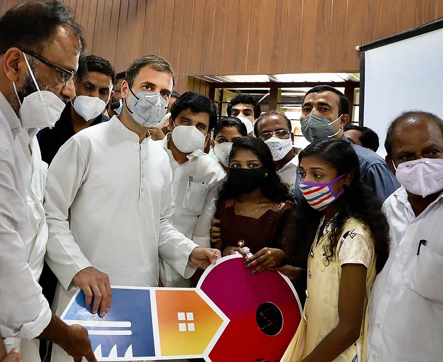 Congress leader and Wayanad MP Rahul Gandhi hands over key of a newly constructed house to the Kavya and Krithika, the two sisters who were orphaned in the landslide tragedy of Kavalappara last year, at a programme in Malappuram, Monday, Oct. 19, 2020. Gandhi has instructed for the construction of the house after knowing their plight. Credit: PTI Photo