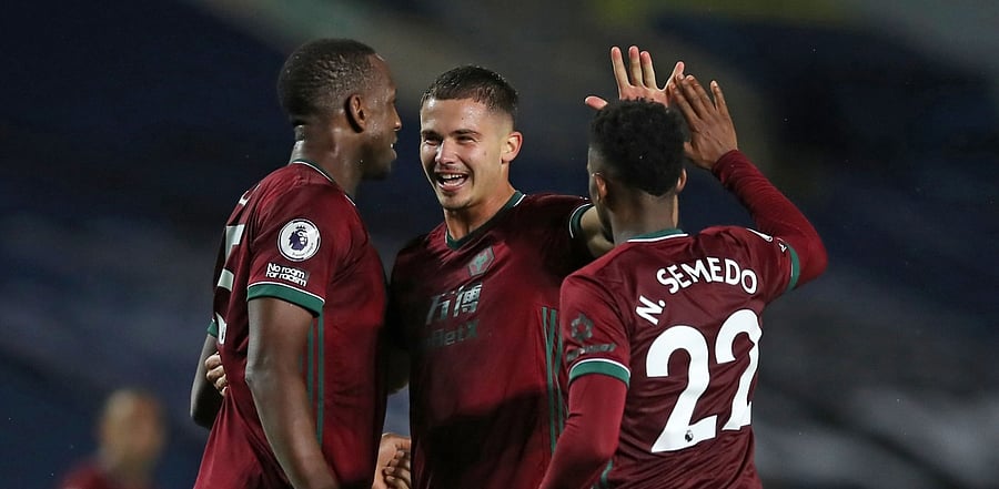 Wolverhampton Wanderers' Belgian midfielder Leander Dendoncker (C) celebrates with Wolverhampton Wanderers' French defender Willy Boly (L) and Wolverhampton Wanderers' Portuguese defender Nelson Semedo (R). Credit: AFP Photo