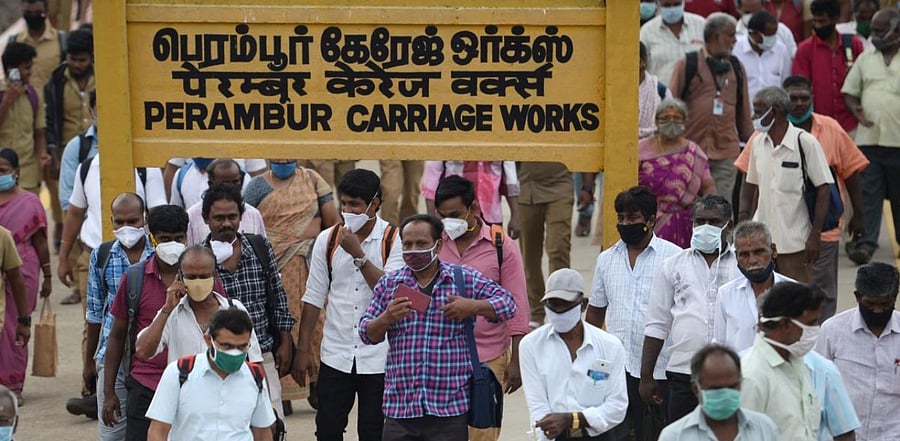 In this picture taken on October 14, 2020, commuters walk through a crowded platform at a railway station in Chennai. Credit: AFP.