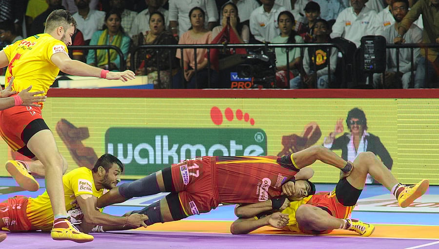 Gujarat Fortunegiants players catch Bengaluru Bulls' Pawan Sehrawat during their Pro-Kabaddi League match in Bengaluru on Saturday. DH Photo/ Pushkar V