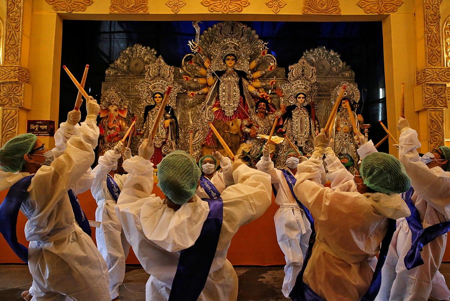 Members play Dandiya inside Vivekananda Sporting Club wearing PPE kits. Credit: Reuters