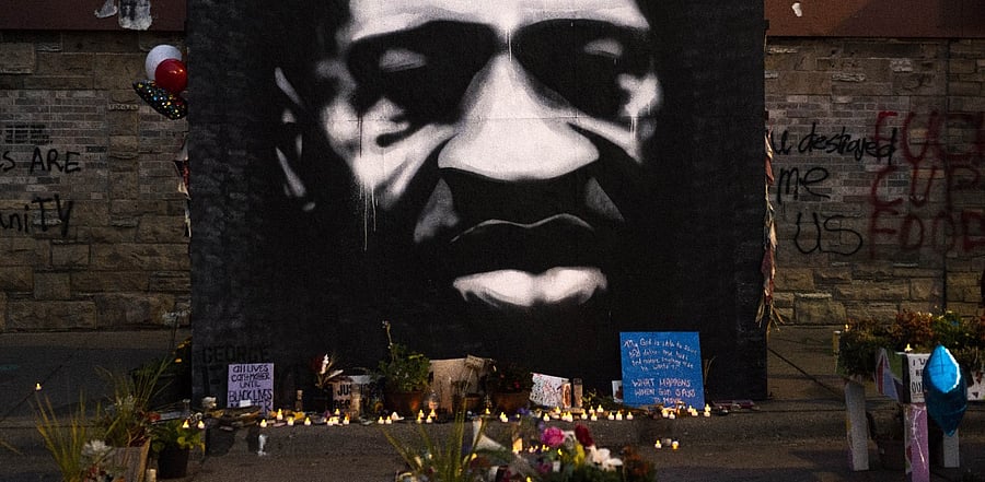 LED candles are placed beneath a portrait of George Floyd during a birthday celebration for him at a memorial site known as "George Floyd Square". Credit: AFP Photo