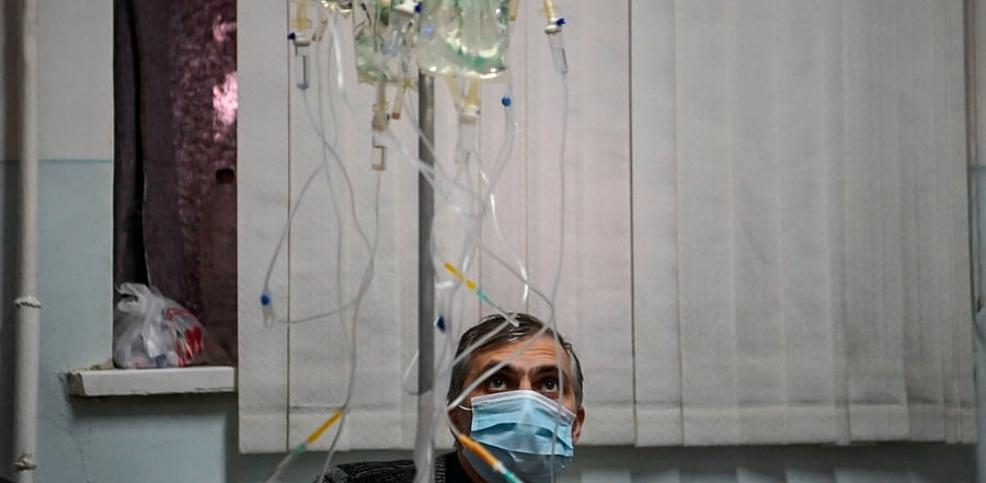 A man looks at IV lines as patients that are suspected cases of the novel coronavirus Covid-19 wait for treatment in a hospital of the city of Stepanakert. Credit: AFP