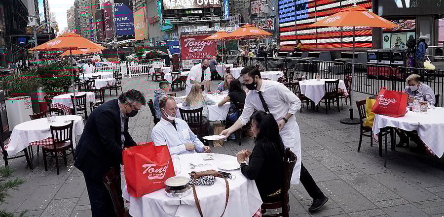 Servers deliver food to a table at a pop up restaurant set up in Times Square in New York. Credits: Reuters Photo