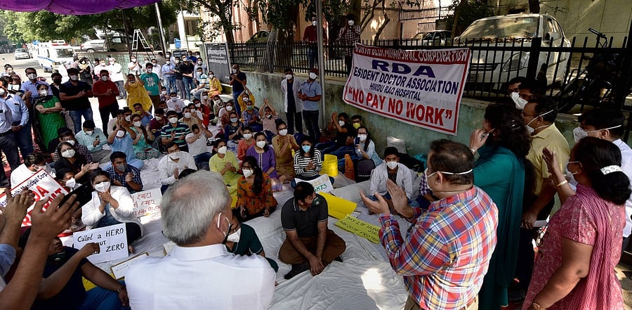 Maruti Sinha, secretary of the Municipal Corporation Doctor Association (MCDA) along with others during an interaction with doctors agitating over non-payment of their salaries, at Hindu Rao Hospital, in New Delhi. Credit: PTI Photo