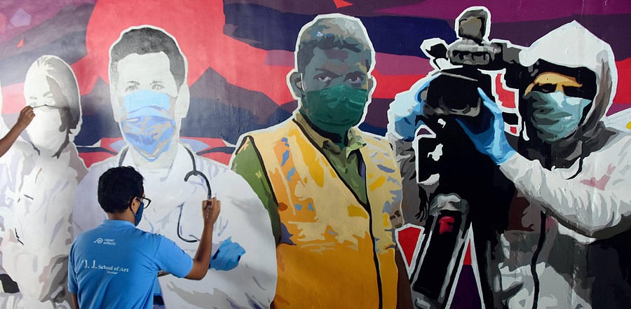 An artist paints a wall outside Dadar Station depicting Covid warriors, in Mumbai. Credit: PTI