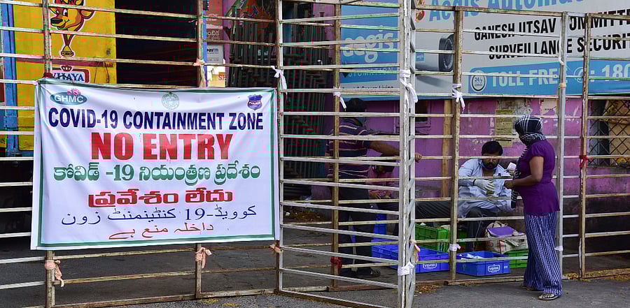A woman buys milk outside an area marked as containment zone during the nationwide lockdown to curb the spread of coronavirus, in Hyderabad. Credit: PTI Photo