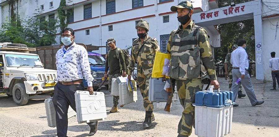 Security personnel carrying Electronic Voting Machines (EVMs) on their way to a polling booth on the eve of first phase of Bihar Assembly Elections, in Gaya. Credit: PTI.