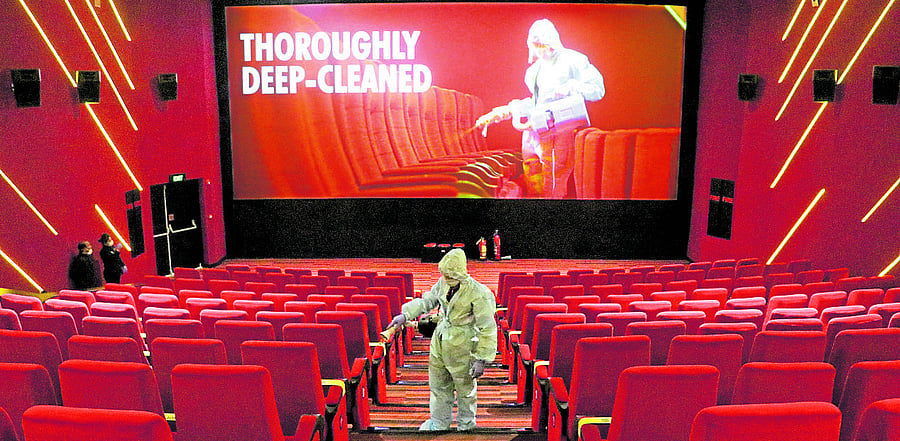 A worker wearing personal protective equipment (PPE) sanitizes seats inside the Inox Leisure movie theatre ahead of its reopening, amidst the outbreak of the coronavirus disease (COVID-19), in Mumbai. Credit: Reuters