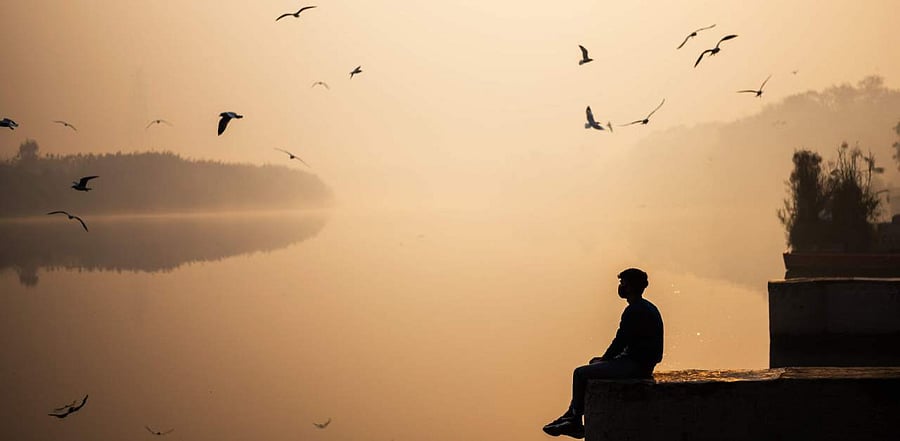 A man poses for pictures on the banks of the Yamuna River during a smoggy morning at sunrise in New Delhi on October 29, 2020. Credit: AFP Photo