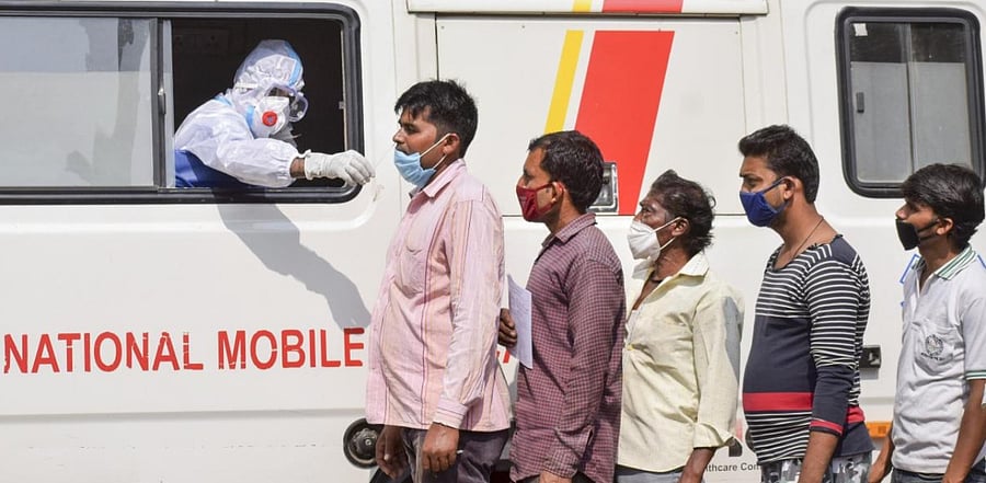  health worker collects a swab sample of a person for the Covid-19 Rapid Antigen Test (RAT), in Prayagraj. Credit: PTI.