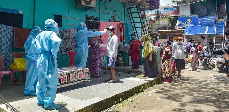 Volunteers wearing protective suits conduct thermal tests at Dharavi, during the fifth phase of the ongoing Covid-19 lockdown. Credit: PTI