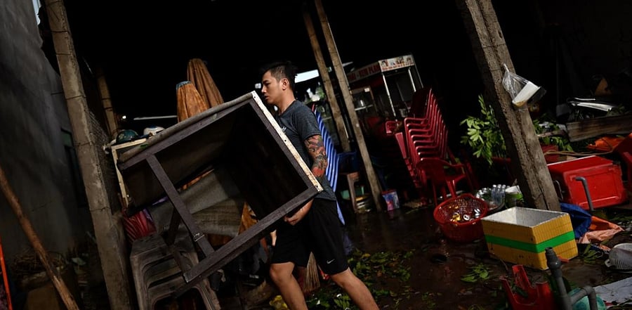 A man clears debris inside an eatery in central Vietnam's Quang Ngai province on October 28, 2020, in the aftermath of Typhoon Molave. Credit: AFP.