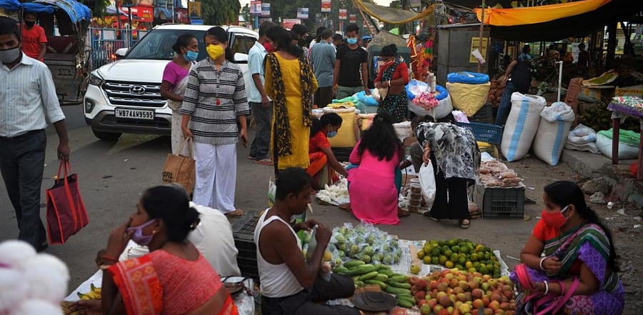 People gather to buy goods in market area along a street in Siliguri. Credit: AFP.