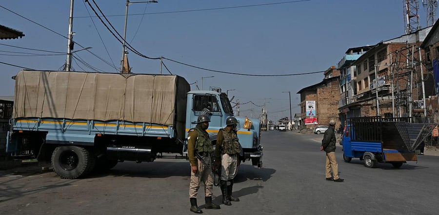 Indian government forces stand guard at a road check point during a one-day strike called by the All Parties Hurriyat Conference (APHC) against Against Indian government decision to open Kashmir land for all Indians, in Srinagar. Credit: AFP Photo