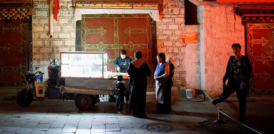 People buy food at a street stall in a market alley in the old city of Lhasa, during a government-organised tour of the Tibet Autonomous Region. Credit: Reuters.