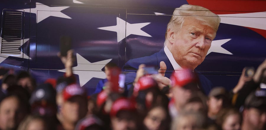  A bus with an image of U.S. President Donald Trump sits next to the crowd during a campaign rally at Richard B. Russell Airport. Credit: AFP Photo
