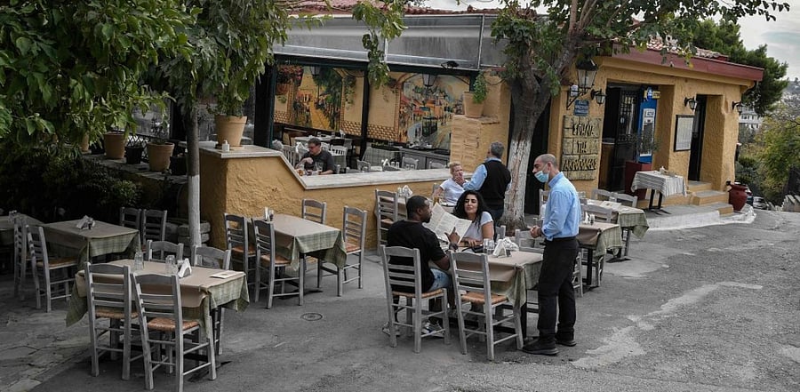 Tourists order a meal in an restaurant in central Athens' Plaka area on November 2, 2020. Credit: AFP.