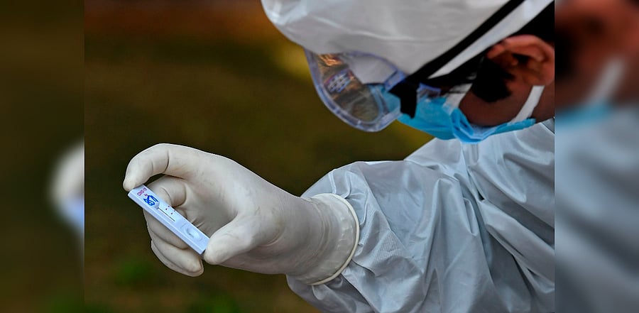 A health worker checks a nasal swab sample collected from a resident during a Rapid Antigen Test (RAT) for the Covid-19 coronavirus in Srinagar. Credit: AFP