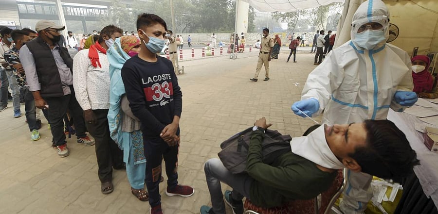 A health worker conducts COVID-19 RAT test at Anand Vihar Bus Terminal, as coronavirus cases surge across the national capital, in New Delhi. Credit: PTI Photo