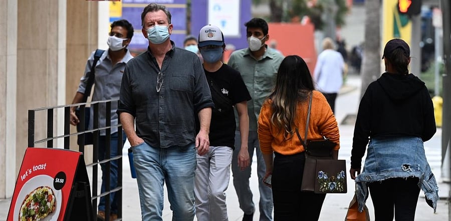 People wearing masks to prevent the spread of coronavirus walk in downtown Los Angeles, California, November 5, 2020 as the country awaits the result of the November 3 US presidential election. Credit: AFP.