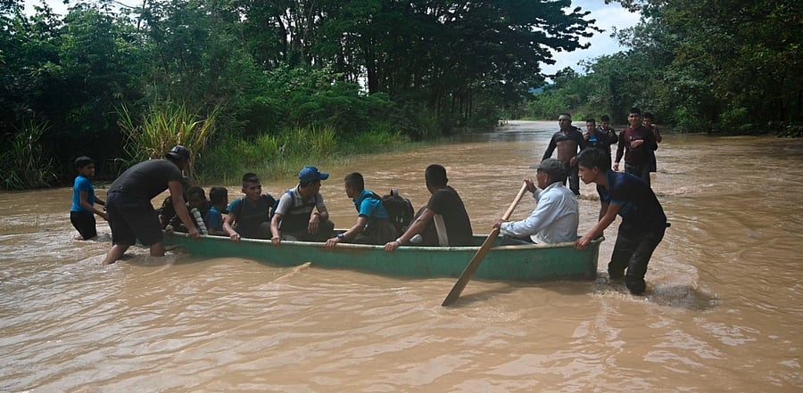People are transported in a boat in a flooded area in Panzos, Alta Verapaz, 220 km north of Guatemala City. Credit: AFP Photo