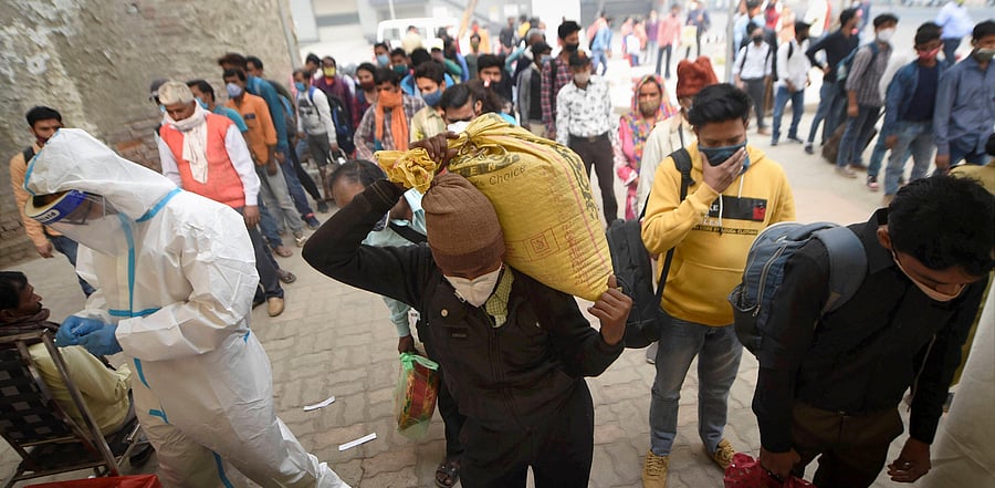 Passengers wait to undergo Covid-19 RAT test at Anand Vihar Bus Terminal, as coronavirus cases surge across the national capital. Credit: PTI