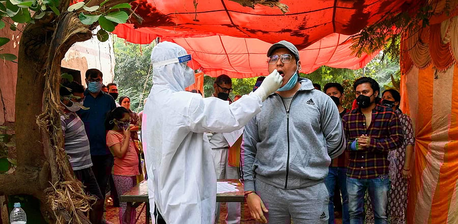 A medical worker collects a swab sample from a man for a RT-PCR Covid-19 test. Credit: AFP Photo
