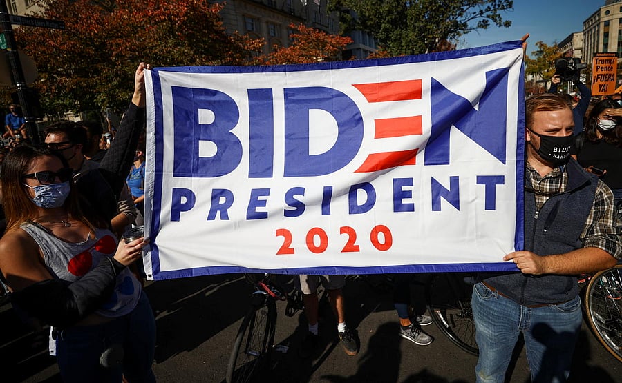 People hold a banner after media announced that Democratic U.S. presidential nominee Joe Biden has won the 2020 U.S. presidential election, on Black Lives Matter Plaza near the White House. Credit: Reuters
