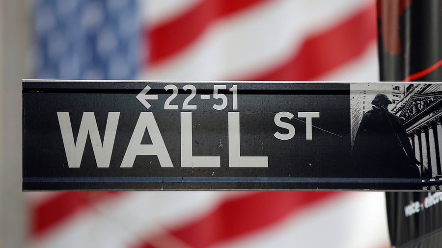 A sign for Wall Street is seen with a giant American flag in the background across from the New York Stock Exchange. Credits: Reuters Photo