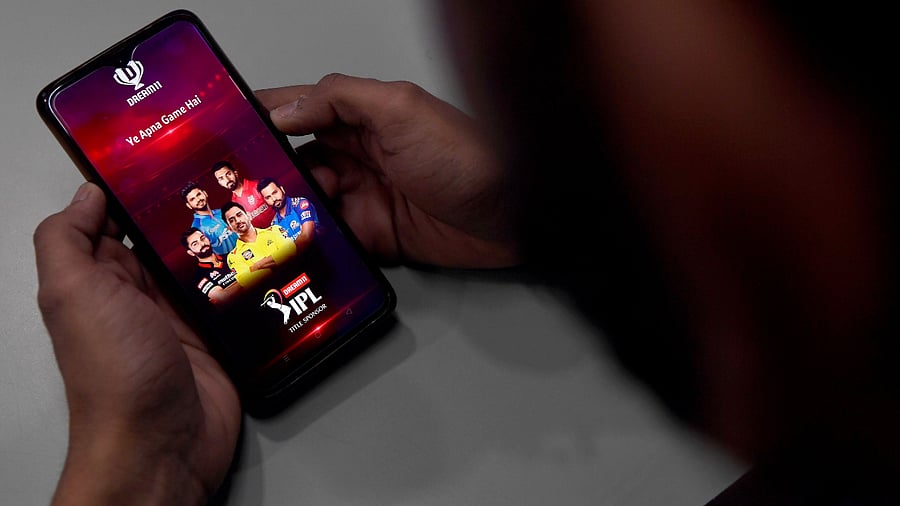 A user checks the Dream11 application for IPL matches on his mobile phone in New Delhi. Credit: AFP Photo