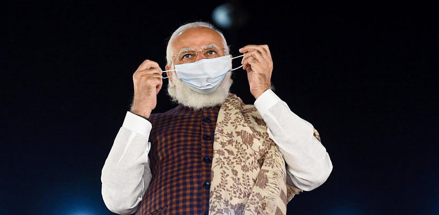 Prime Minister Narendra Modi adjusts his face mask at BJP HQ, a day after National Democratic Alliance (NDA) garnered majority in the Bihar Assembly polls, in New Delhi, Wednesday, Nov. 11, 2020. Credit: PTI