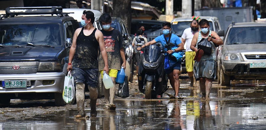 Residents carrying food supplies return to their homes in Marikina City, suburban Manila, on November 13, 2020, a day after Typhoon Vamco hit the capital area bringing heavy rains and flooding. Credit: AFP Photo