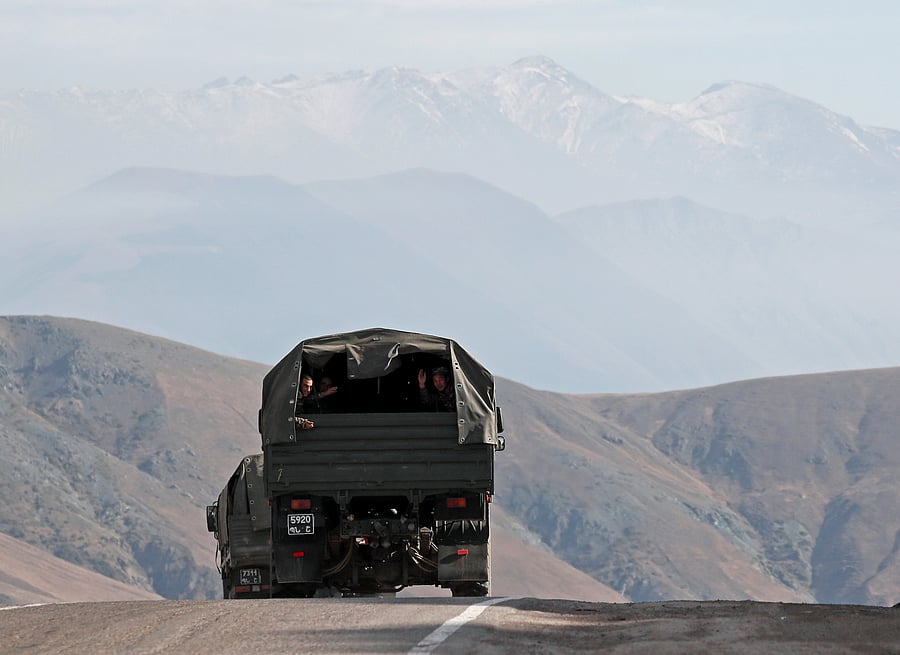 Ethnic Armenian soldiers ride in the back of a truck on the road that links Armenia and the region of Nagorno-Karabakh, November 15, 2020. Credit: REUTERS