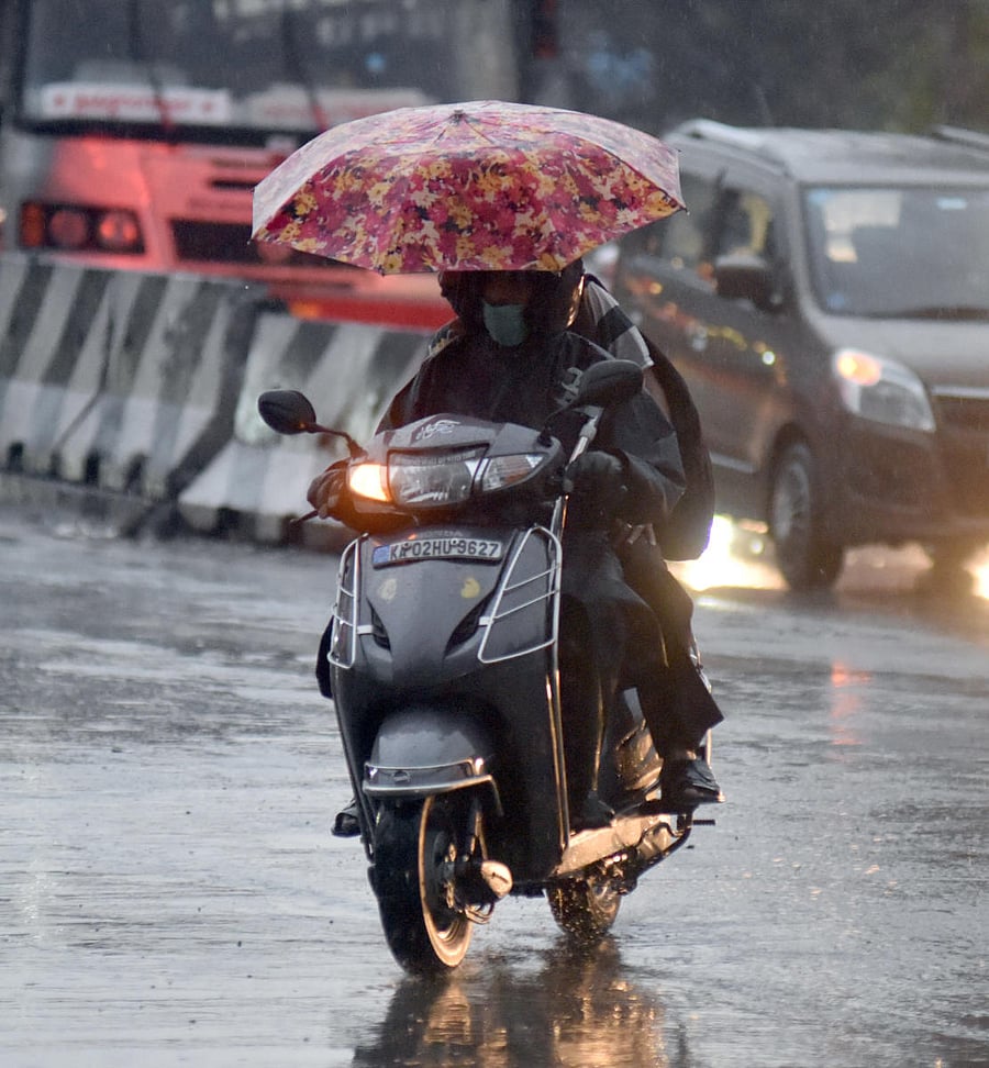 A motorcyclist rides on Mysuru Road during the Sunday evening rainfall. DH PHOTO/ANUP RAGH T