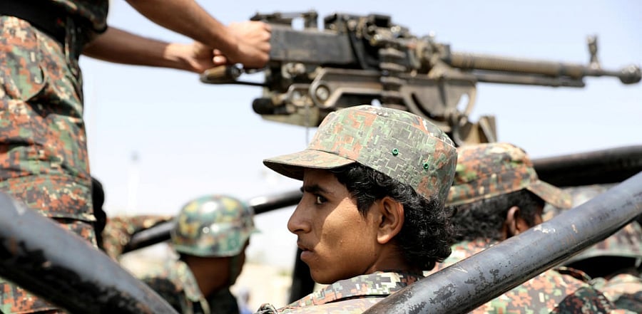 A police trooper rides on the back of a patrol truck during the funeral of Houthi fighters killed during recent battles against government forces, in Sanaa, Yemen. Credit: Reuters file photo.