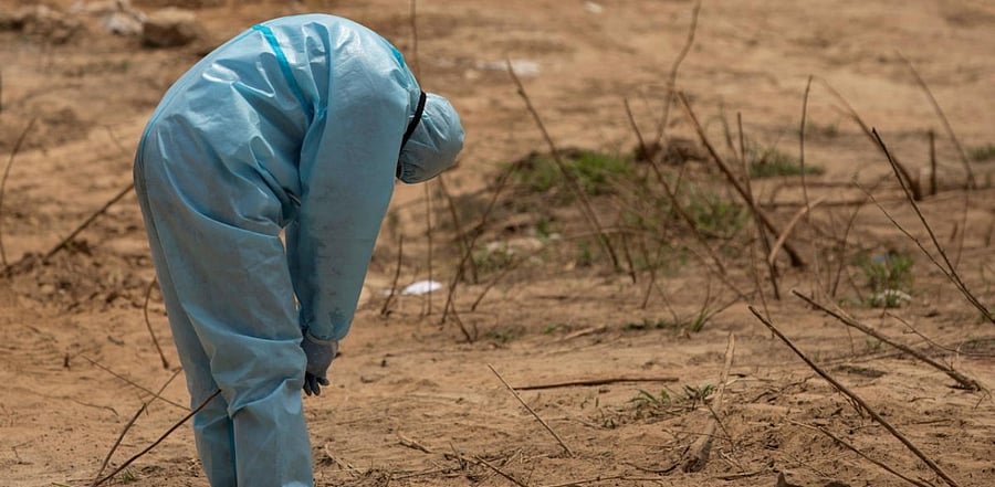 A health worker reacts before the burial of a Central Reserve Police Force (CRPF) officer who died from the coronavirus disease (COVID-19), at a graveyard in New Delhi, India, April 29, 2020. Credit: Reuters Photo