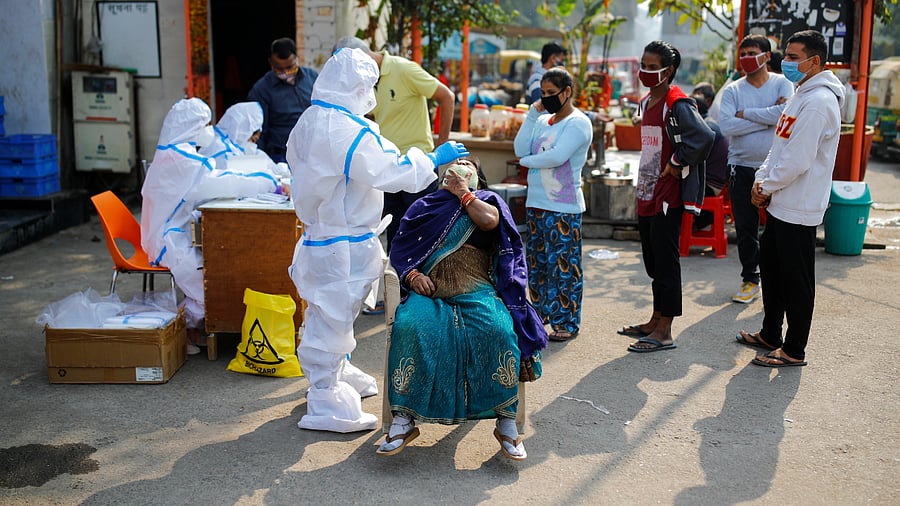 A healthcare worker collects a swab sample from a man in Noida. Credit: Reuters Photo