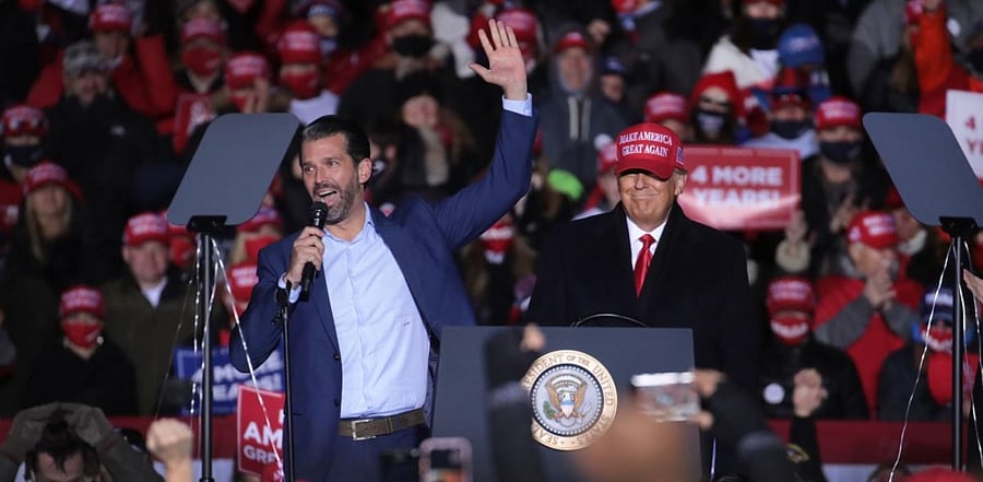 President Donald Trump listens as his son Don Jr. speaks during a campaign rally at the Kenosha Regional Airport on November 02, 2020. Credit: AFP Photo
