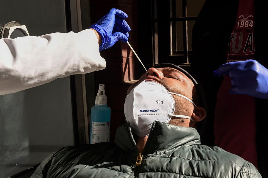 A health worker collects a swab sample from a man at a Covid-19 coronavirus screening site. Credit: AFP Photo