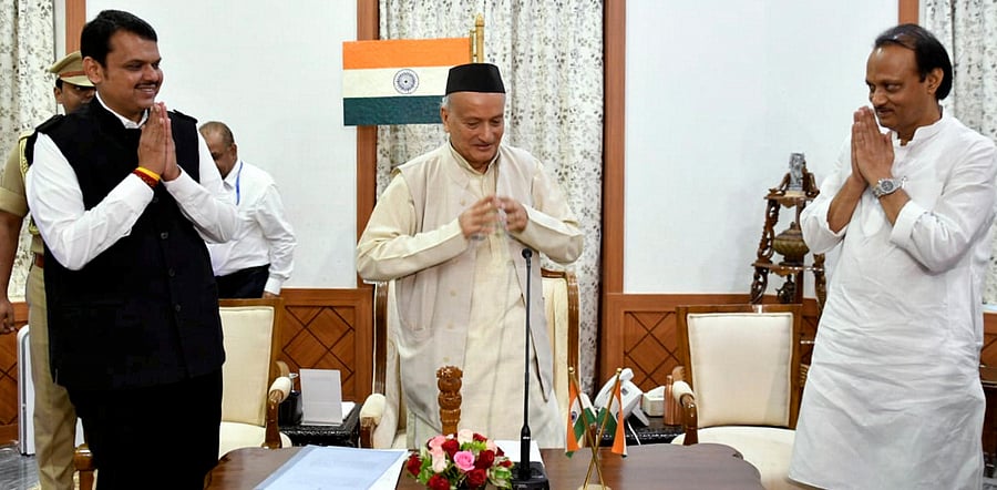 Maharashtra Governor Bhagat Singh Koshyari flanked by the then newly-appointed Chief Minister of Maharashtra Devendra Fadnavis and his Deputy CM Ajit Pawar, during an oath-taking ceremony, in Mumbai, Saturday, Nov. 23, 2019. Credit: PTI Photo