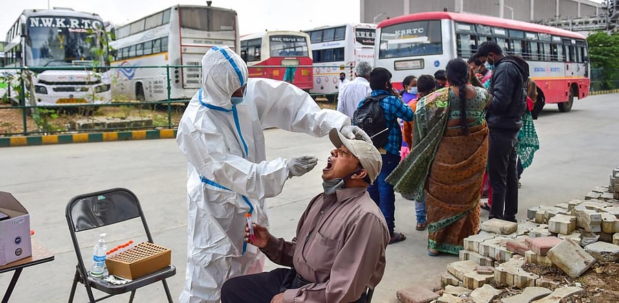 A health worker collects sample for Covid-19 test, at KSRTC bus stand in Bengaluru. Credit: PTI Photo